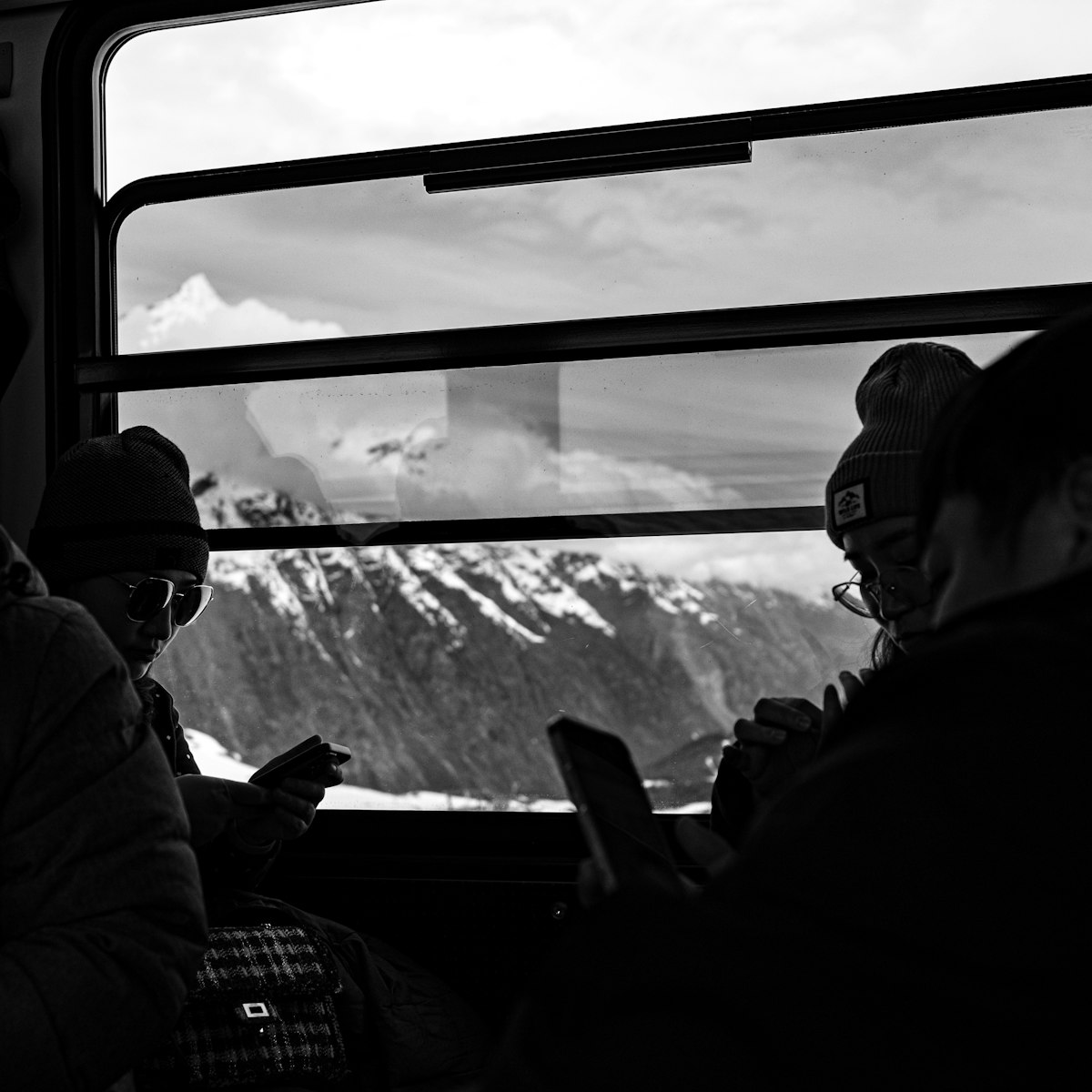 Commuters absorbed in their phones during a train journey